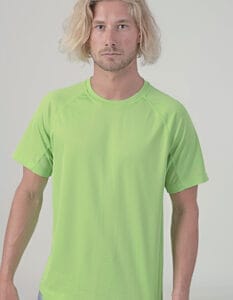 Mand med skulderlangt, lyst hår står stille iført en lys grøn T-shirt, set foran en neutral, lysegrå baggrund.