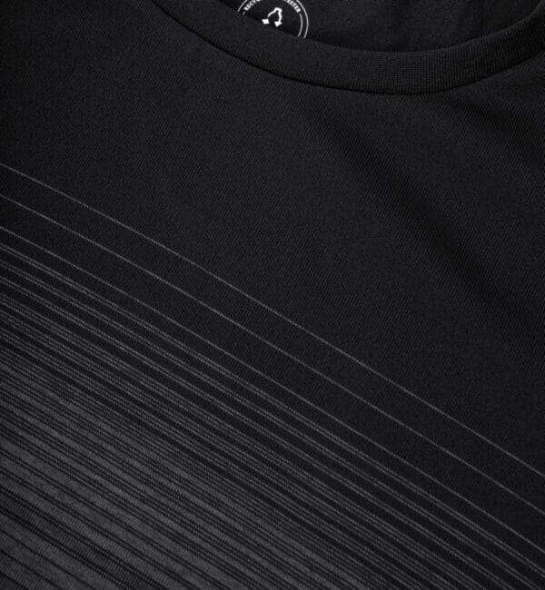 g11024_900_pack_5 Sort T-shirt design med tynde, hvide linjer i et mønster, der løber langs bunden. En del af nakkelabelen med utydeligt hvidt tryk er synlig øverst.