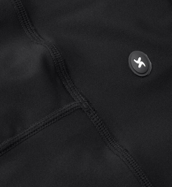 g11049_900_pack_5 Sort stof med syninger, og en lille rund mærke, som har et hvidt logo i midten.