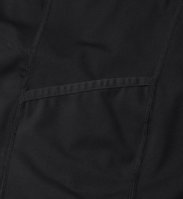 g21049_900_pack_5 Sort stof med syninger og en lige søm i midten af billedet. Stoffets overflade ser glat ud uden tekstur eller mønster.