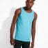 Mand bærer en lyseblå tanktop og sorte leggings, mens han står i et minimalistisk, hvidt indendørs miljø. Han kigger til siden med naturligt lys, der kaster skygger bag ham.