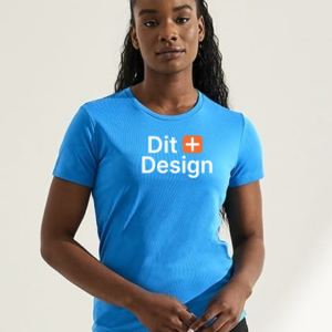 Person bærer en blå T-shirt med teksten "Dit Design" i et lyst rum. Personen står oprejst med hænderne let samlet foran sig.