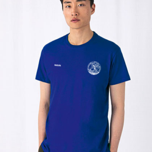 Person bærer en blå T-shirt med teksten "NAVN" på brystet og et rundt hvidt logo. Personen står mod en hvid baggrund, og ser direkte fremad.