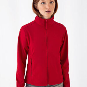 Person med rød trøje står, ser lige frem; trøjen har høj hals. Baggrund er enkel og lys, hvilket fremhæver trøjen. Ingen tekst er til stede.