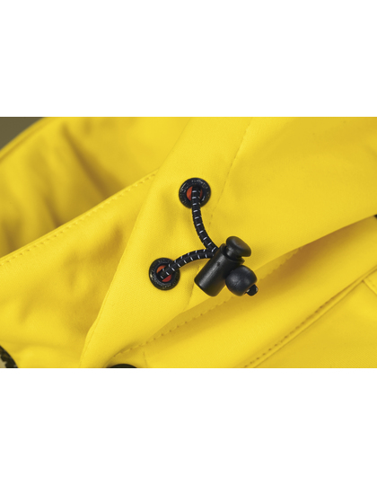 Sort toggle-lukning sidder på et stykke gult stof, muligvis en beklædningsgenstand, der danner baggrunden.