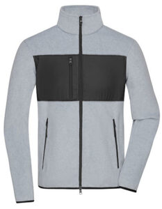 Grå sweatshirt med lynlås og sort panel på brystet hænger flat. Lynlåslommer er synlige på hver side. Baggrund er enkel og ensfarvet. Ingen tekst til stede.