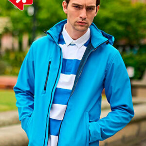 Jeg kan ikke se, hvem personen er på billedet, men en person iført en blå jakke står med hænderne i lommerne i en park. Grønne træer i baggrunden.