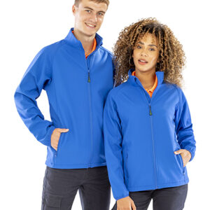 To personer iført blå trøjer står side om side. Den ene har hænderne i lommerne, mens den anden står med hænderne langs siden i et neutralt rum.