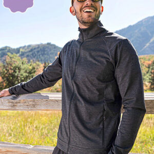 Mand kigger op og smiler iført solbriller og jakke, læner sig mod træhegn; på mark med bjerge i baggrunden. Tekst: "NEW".