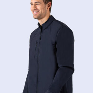 Mand iført en mørk jakke står smilende. Jakken har en lynlås foran og en brystlomme. Personen vises fra taljen og op, mod en lys baggrund.