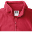 Rød fleecejakke med høj krave og lynlås i en indendørs opsætning. Et mærkat bag kraven viser størrelsen XL.