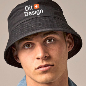 En person bærer en sort bøllehat med teksten "Dit Design" trykt på forsiden. Personen er iført en denimjakke, og baggrunden er neutral.