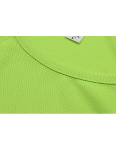 Lysegrøn t-shirt ligger fladt, viser en del af halskanten og lidt af mærket. Stoffet har en mesh-lignende tekstur, der antyder lethed og åndbarhed.